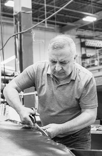 man working on upholstering a custom chair in a toronto furniture factory